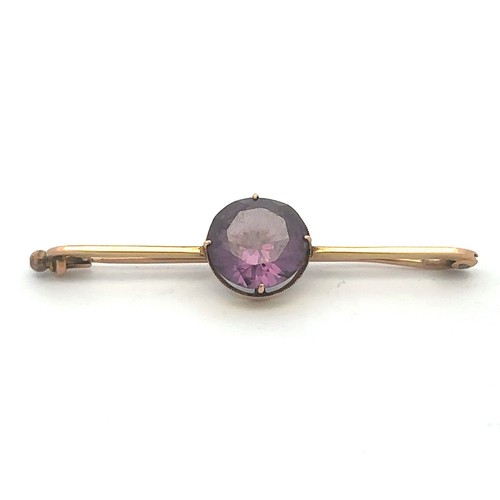 435 - A synthetic colour change sapphire bar brooch, stamped 15ct.  Sapphire 11mm in diameter, brooch 52mm... 