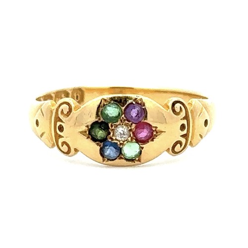 445 - An 18ct gold multi gemstone ring with scroll shoulders, set with diamond, emerald, sapphire, ruby, a... 