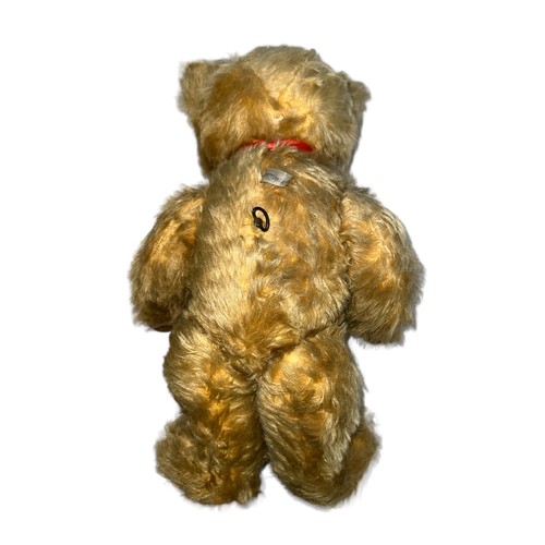 249 - A Pedigree musical teddy bear, with orange and black eyes, jointed arms and legs and red bow. Music ... 