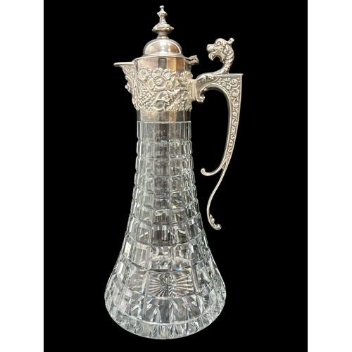 182 - A 1970 silver and cut glass claret jug. Elaborate silver mount with mask head handle, Bacchanalian m... 