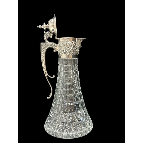 182 - A 1970 silver and cut glass claret jug. Elaborate silver mount with mask head handle, Bacchanalian m... 