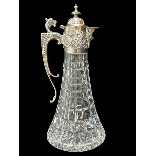 182 - A 1970 silver and cut glass claret jug. Elaborate silver mount with mask head handle, Bacchanalian m... 