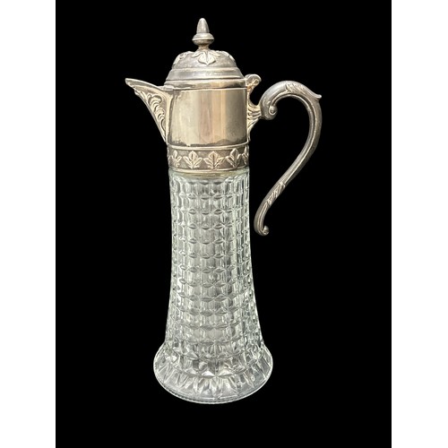 391 - A white metal and glass claret jug. Approx 33.5cm in height.