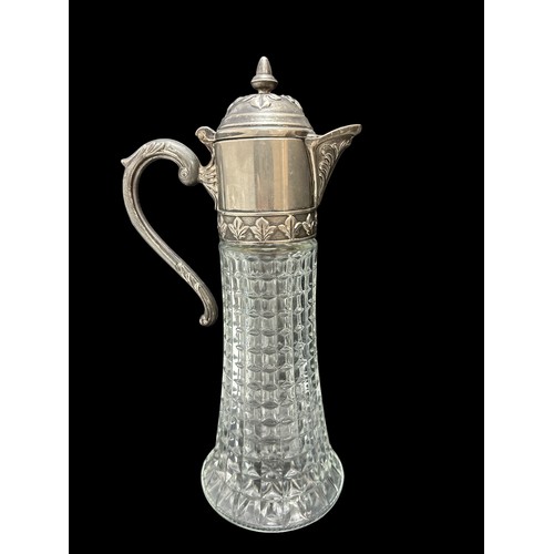 391 - A white metal and glass claret jug. Approx 33.5cm in height.