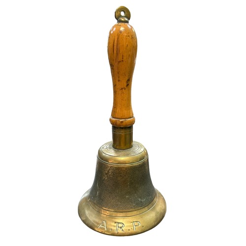 121 - An Air Raid Precautions (ARP) brass hand bell with wooden handle. Marked J.B. and 39.