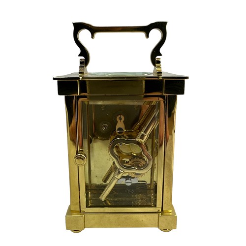 132 - A brass cased carriage clock with bevelled glass panels, Matthew Norman, Swiss Made, complete with k... 