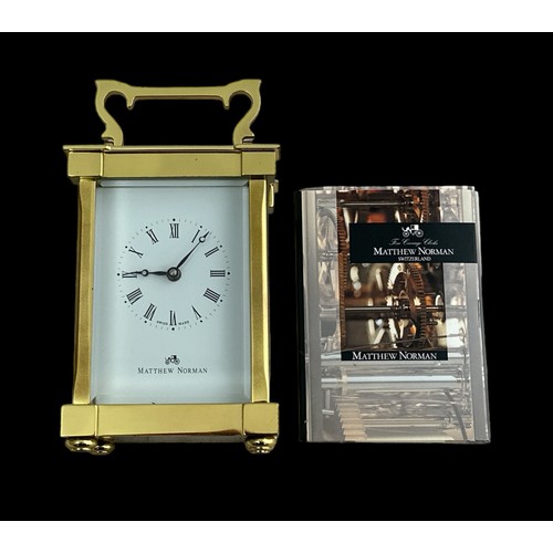 132 - A brass cased carriage clock with bevelled glass panels, Matthew Norman, Swiss Made, complete with k... 