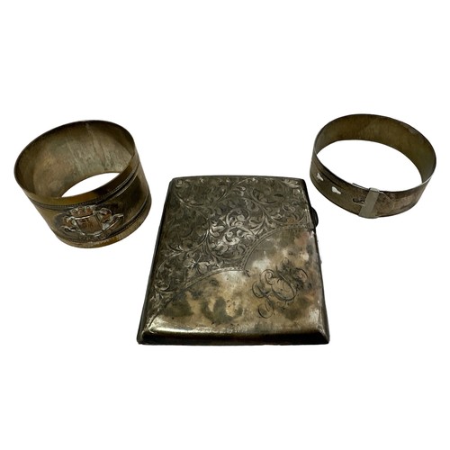 217 - A silver cigarette case (dented and tarnished) and an adjustable silver bangle. Also a trench art Yp... 