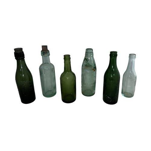 115 - Selection of six various glass bottles to include; a Wood Brothers Daventry Codd Bottle with marble,... 