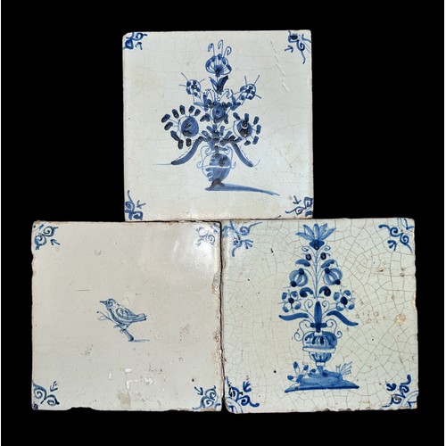 143 - Three blue and white hand painted earthenware tiles Delft, two having vases of flowers design and th... 