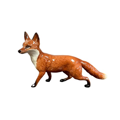 13 - Beswick, a group of three Fox figurines, to include; larger prowling fox (length 22.5cm) and two cur... 