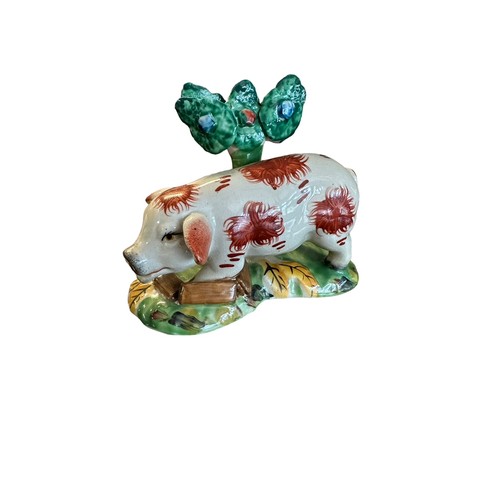 418 - Staffordshire, a Staffordshire hand painted Pig figurine stood before a tree. Height 12cm.