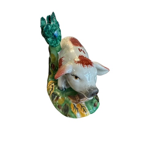 418 - Staffordshire, a Staffordshire hand painted Pig figurine stood before a tree. Height 12cm.