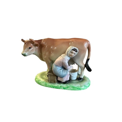 420 - Ceramic milk maid milking cow figure (likely Staffordshire). Height 11.5cm, length 14cm.