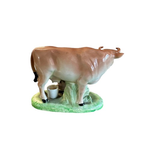 420 - Ceramic milk maid milking cow figure (likely Staffordshire). Height 11.5cm, length 14cm.