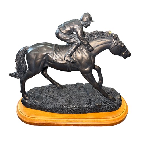 28 - Spelter model of a racehorse and jockey on wooden base, length approx. 26cm.