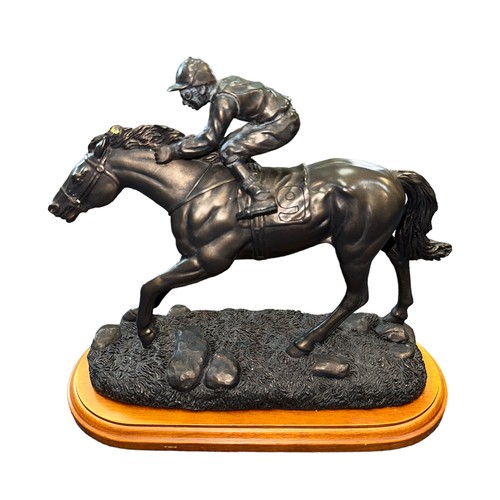 28 - Spelter model of a racehorse and jockey on wooden base, length approx. 26cm.