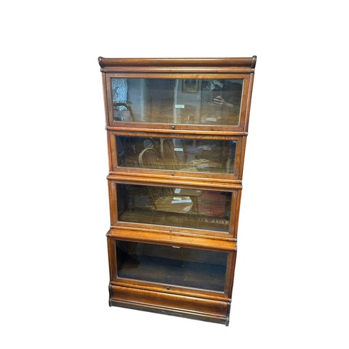 447 - An oak four section Globe Wernicke sectional bookcase with lift up glass fronts, also plinth base an... 