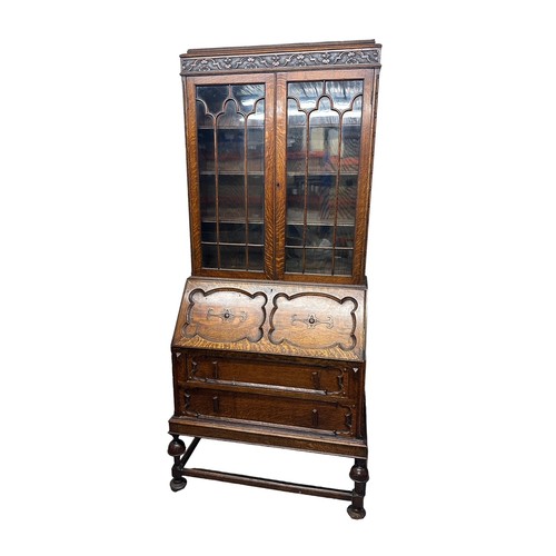 451 - Oak bureau bookcase, on four legs with two round feet (one damaged), two lower draws, fold out writi... 