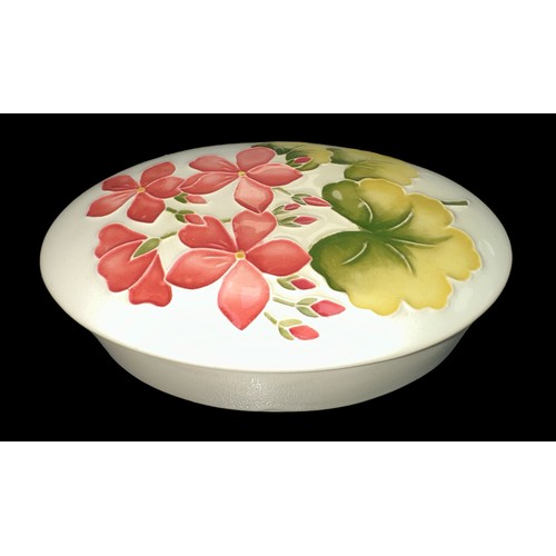 198 - Moorcroft - A Moorcroft pottery, oval trinket box with lid, decorated with pink geranium on a cream ... 