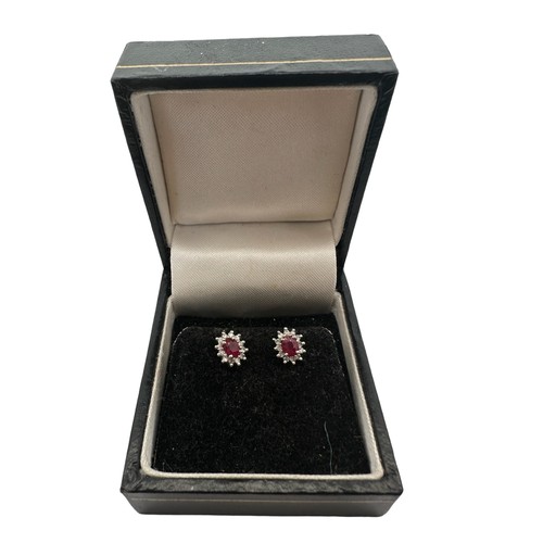 21 - A pair of ruby and diamond cluster earrings. Set in hallmarked 9ct white and yellow gold.

Please se... 