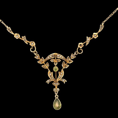 28 - An Edwardian peridot and seed pearl pendant necklace stamped 14K on chain stamped 9ct. Overall lengt... 