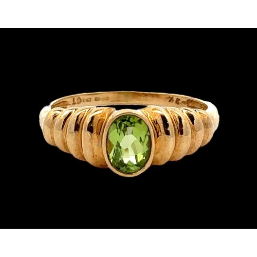 56 - An oval peridot 9ct gold ring, size Q. Weight 2.58g.

Please see the buyer's terms and conditions fo... 