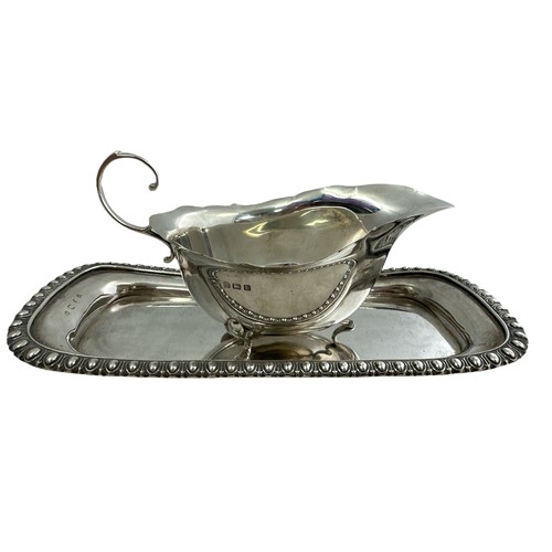 126 - A silver cream jug and tray. Cream jug, 15cm in length, by S Lesser & Sons Ltd, Birmingham 1929. Tra... 