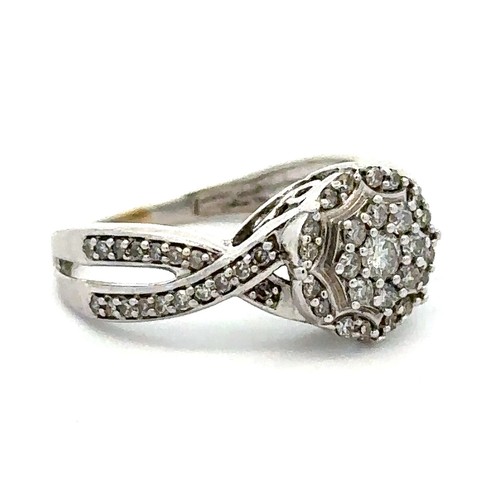 40 - A 9ct white gold diamond cluster ring with a crossover split shank. London hallmarks. Size N. Weight... 