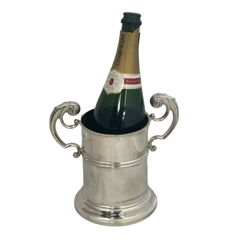 163 - A silver bottle holder with scroll handles by Walker & Hall. Hallmarks for Chester 1906. Height appr... 