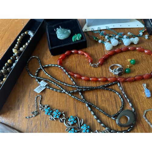 9 - A number of pieces of hardstone and gem set jewellery, including a jade Buddha pendant, a tagua nut ... 