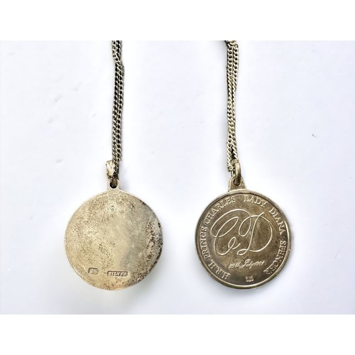 23 - Two silver medallion pendant necklaces. One with a floral design one on one side and stamped 'SS' an... 