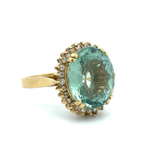 31 - An oval cut aquamarine and diamond cluster ring set in 18ct gold. Aquamarine is approx 15mm x 12mm w... 