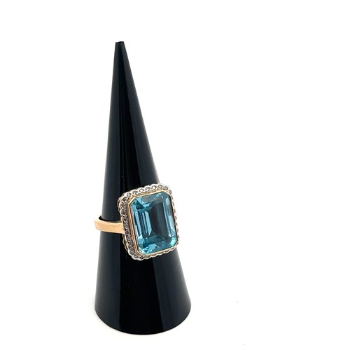 89 - A topaz and diamond cluster dress ring, size M. The  emerald cut topaz approx 10mm x 14mm. Makers ma... 