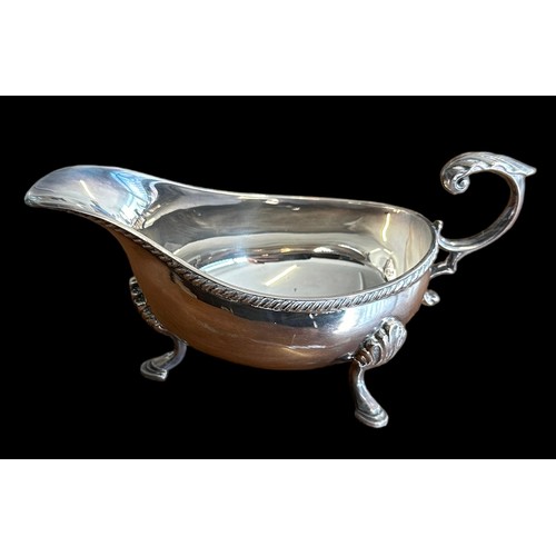 195 - Hampton Utilities, silver gravy boat with decorative handle and feet. Marked HU for Hampton Utilitie... 