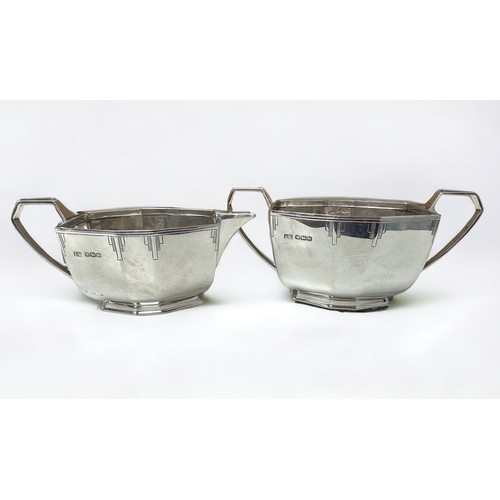 198 - An Art Deco silver cream jug and silver sugar bowl with panelled oval form and engraved decoration. ... 