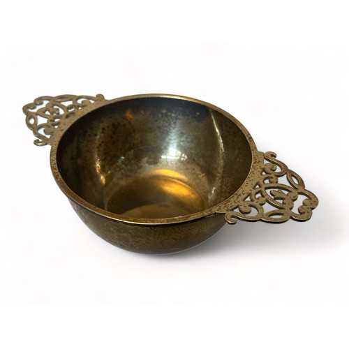 205 - A silver quaich style bowl with twin pierced handles. 10cm diameter, 16cm in length. S Blanckensee &... 