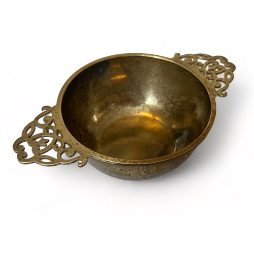 205 - A silver quaich style bowl with twin pierced handles. 10cm diameter, 16cm in length. S Blanckensee &... 