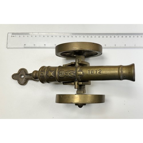 78 - Heavy brass decorative cannon, two pieces with working wheels, cannon inscribed ‘1812’. Length 28cm,... 