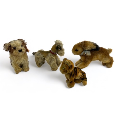 254 - Four vintage animal figures, believed to be Steiff. Includes a sitting tiger cub, a rabbit with a bl... 