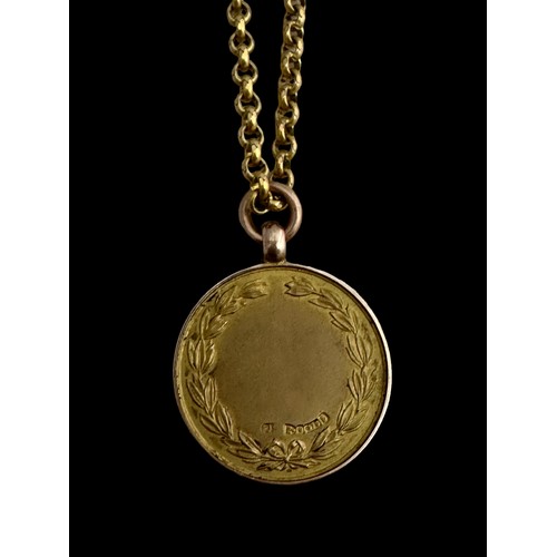 42 - A 9ct gold medallion on a yellow metal chain. Medallion with a profile of a golfer on one side and l... 