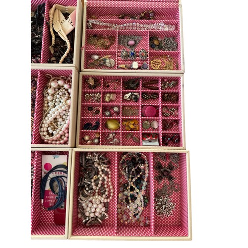 54 - A pastel coloured Stackers six section jewellery box containing a large amount of costume jewellery.... 