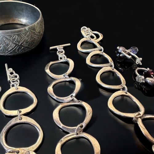 45 - A selection of silver and white metal jewellery. Includes a gate link bracelet, a silver and purple ... 