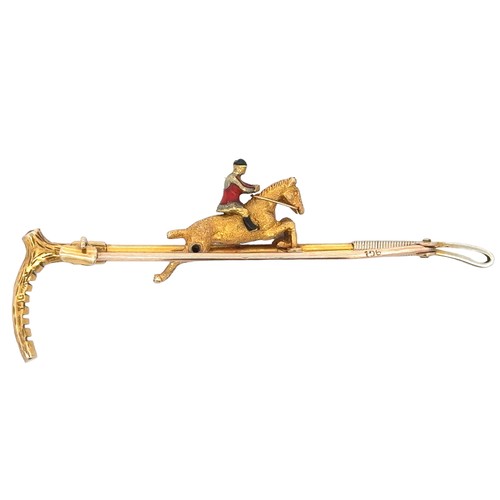 15 - A 9ct gold bar brooch in the form of a riding crop with a gold and enamel horse and jockey. Set with... 