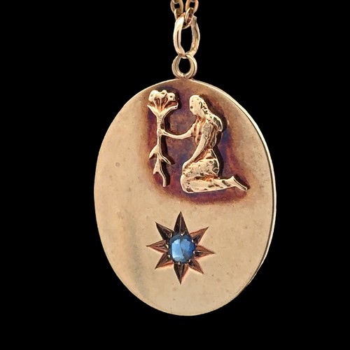 21 - A 9ct gold oval zodiac pendant with raised Virgo symbol ans sapphire in star beneath. Stamped 'Albio... 