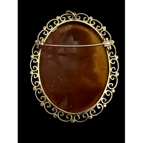 16 - A large finely-carved shell cameo in 9ct gold filigree scroll surround which can be worn as a brooch... 