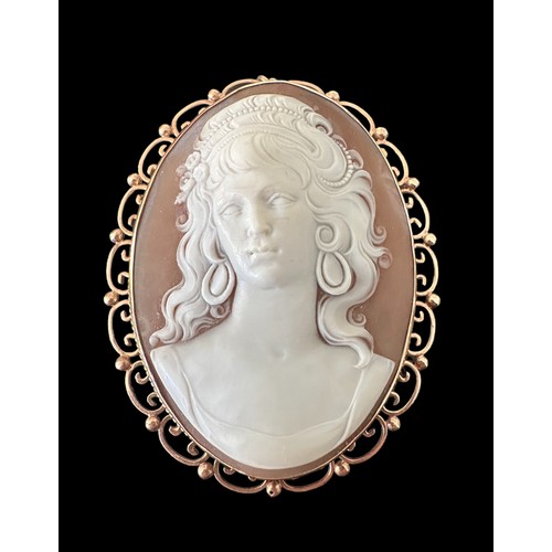 16 - A large finely-carved shell cameo in 9ct gold filigree scroll surround which can be worn as a brooch... 