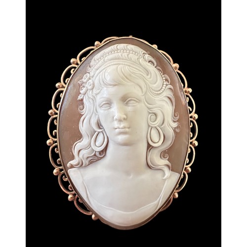 16 - A large finely-carved shell cameo in 9ct gold filigree scroll surround which can be worn as a brooch... 