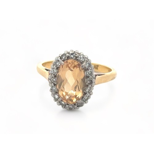 27 - An oval imperial topaz and diamond cluster ring, stamped 18ct and PLAT, by maker W.E.G. Topaz approx... 