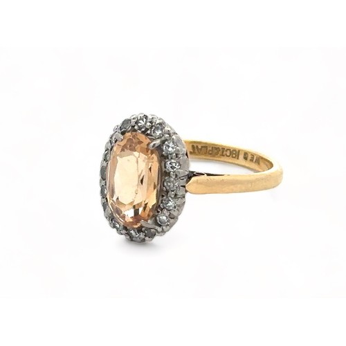 27 - An oval imperial topaz and diamond cluster ring, stamped 18ct and PLAT, by maker W.E.G. Topaz approx... 